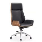 Jurish High Back Executive Chair featuring a walnut veneer shell, black PU upholstery, aluminium base with nylon castors, and single-locking knee tilt mechanism, set in a modern office environment.